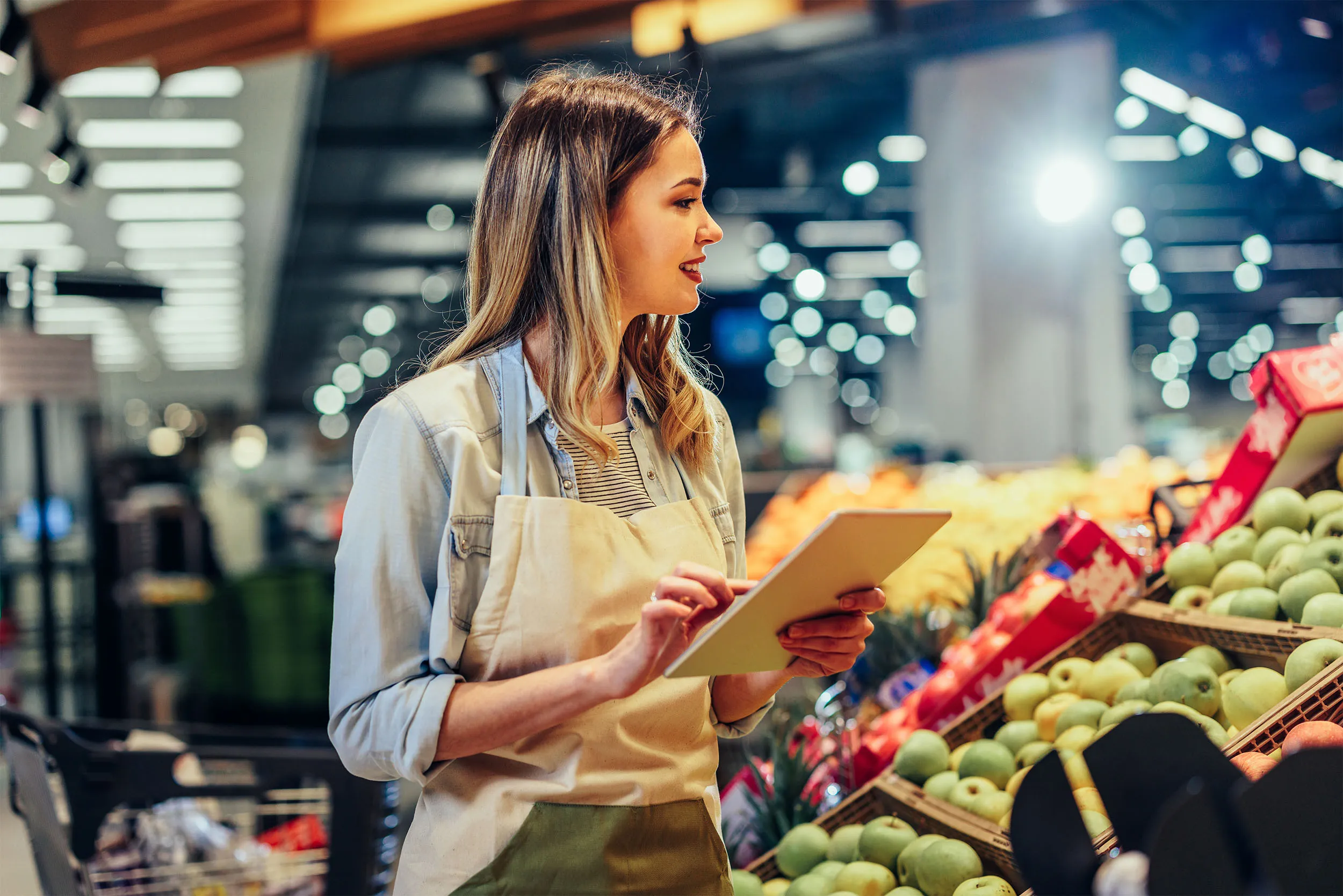 Grocer checking stock in the produce aisle