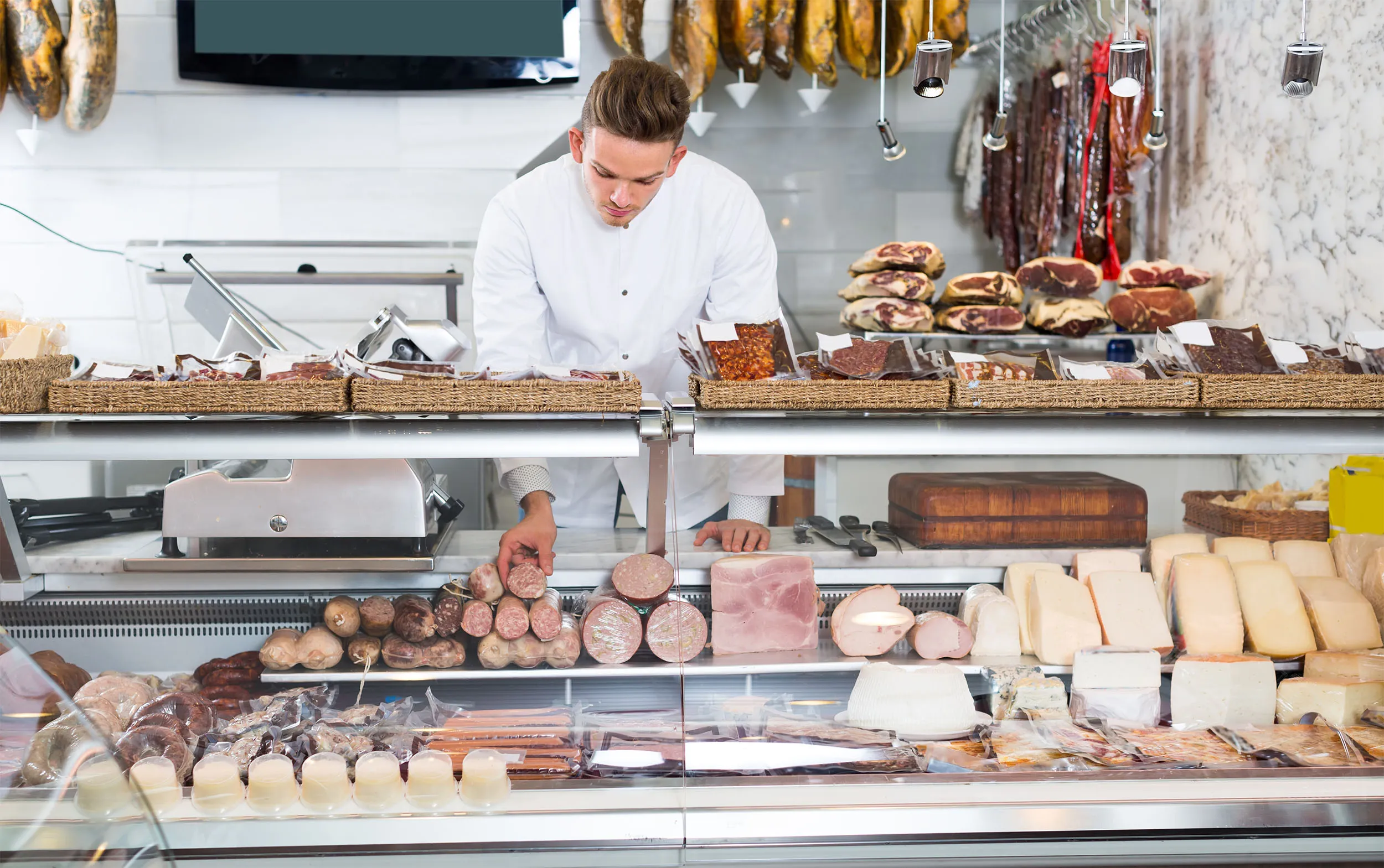 Butcher serving a customer at a specialty market counter